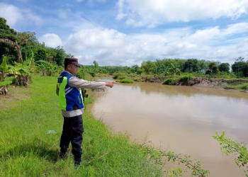 Antisipasi Banjir, Personel Polsek Belitang III Cek Debit Air Sungai Secara Berkala Selama Musim Penghujan